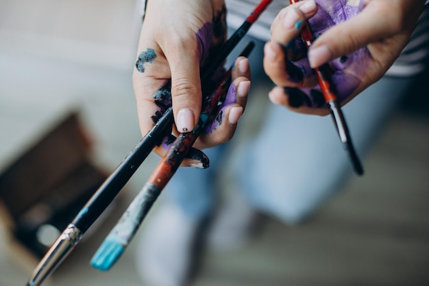 Female hands with painting brushes