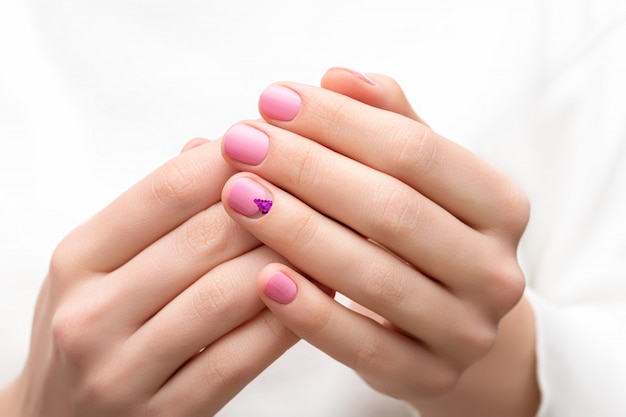 Female hands with pink nail design.