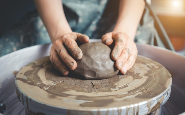 Foto gratuita mani femminili che lavorano al tornio di ceramica