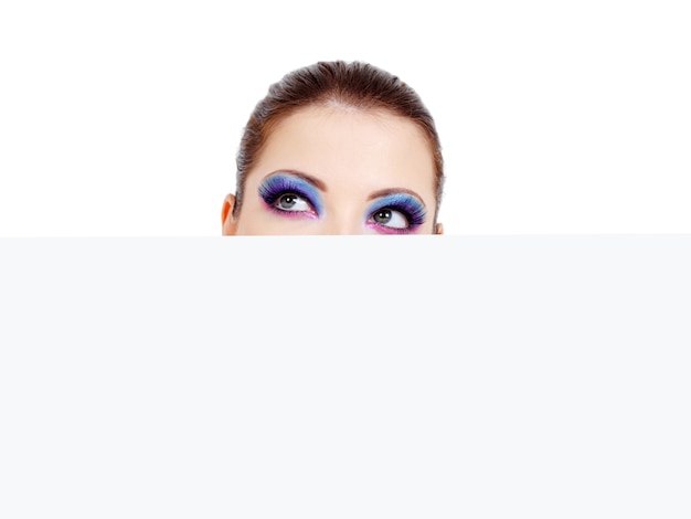 Free photo female head with beautiful eyes looking out of a blank white banner