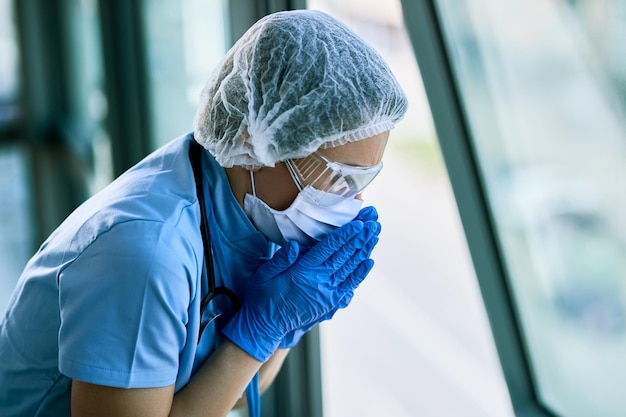 COVID19 전염병 동안 병원에서 일하는 동안 기침하는 여성 의료 종사자