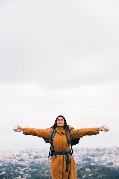 A female hiker outstretching her hands enjoying the fresh air on top of mountain