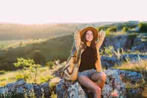 Free photo female hiker relaxing on rock