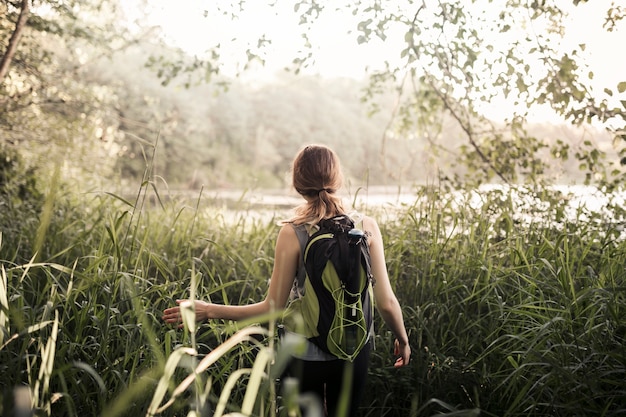 Female hiker walking in the green grass