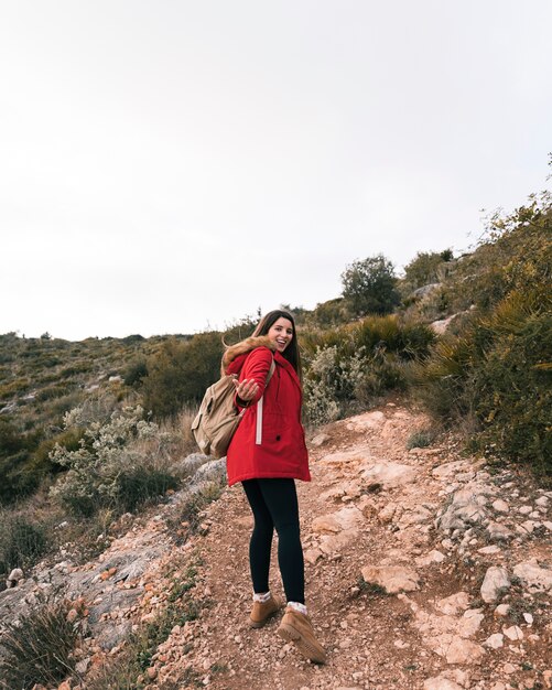 A female hiker with her backpack walking on mountain trail