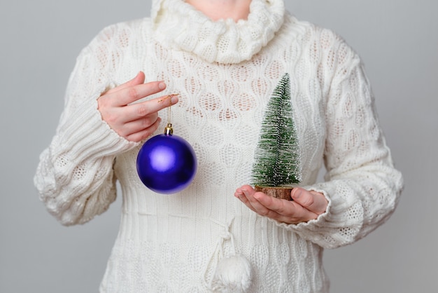보라색 크리스마스 공 및 장식 작은 나무를 들고 여성