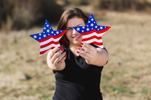 Female holding USA flag stars and looking at camera