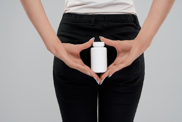 Free photo female holding white container of pills