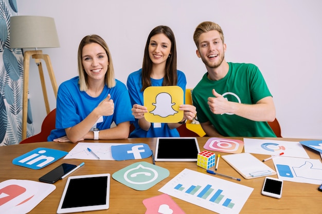 Female holding youtube logo with his friends showing thumbup sign