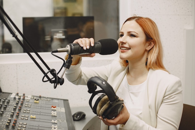 Female host communicating on Microphone. Woman in radio studio.