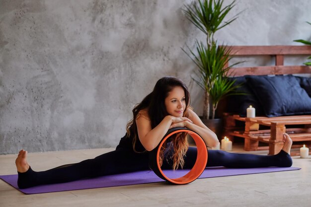 The female is stretching her body on a floor in a rest room.