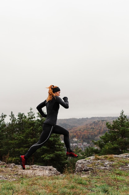 Бесплатное фото Женский бегун прыгает через скалы