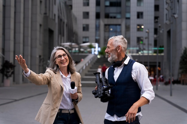 Free photo female journalist with her cameraman