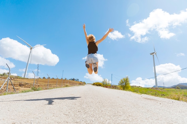 空の道で跳んでいる女性