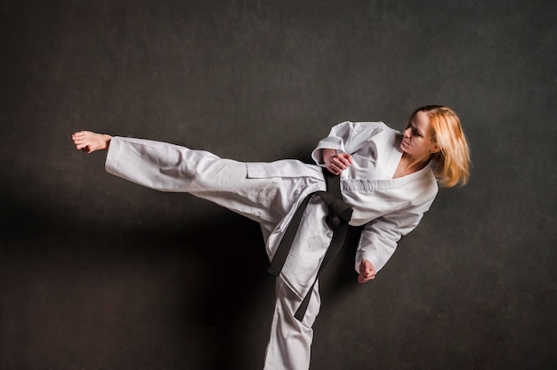 Female karate fighter kicking front view