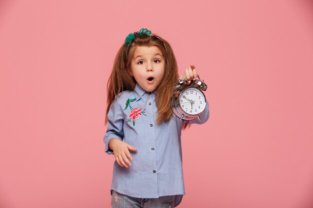目と口を大きく開いて保持している女性の子供の時計を保持しているほぼ6ショックを受けているか揺れている