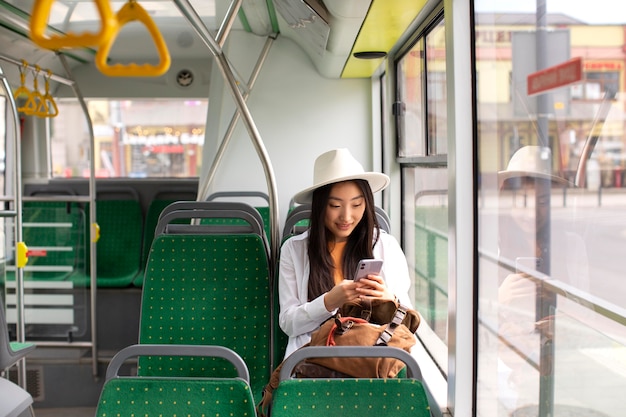 Foto gratuita viaggiatrice locale femminile che soggiorna in un autobus