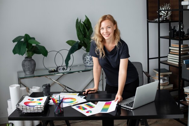 Женский дизайнер логотипов работает в своем офисе на графическом планшете