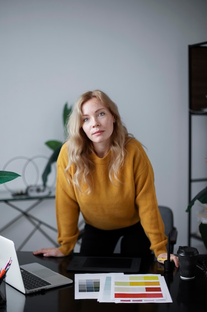 Female logo designer working on her tablet connected to a laptop