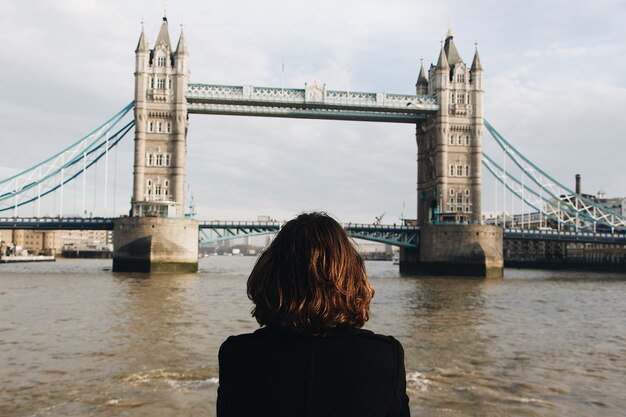 Female looking at the famous Tower Bridge St UK during daytime Tower Bridge in the UK