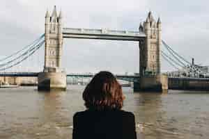 Free photo female looking at the famous tower bridge st uk during daytime tower bridge in the uk