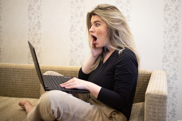 Female looking at the laptop with a surprised face