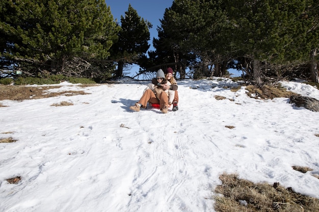 Foto gratuita amanti femminili su una slitta durante il loro viaggio invernale