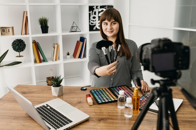 Female make-up blogger with streaming with camera and laptop