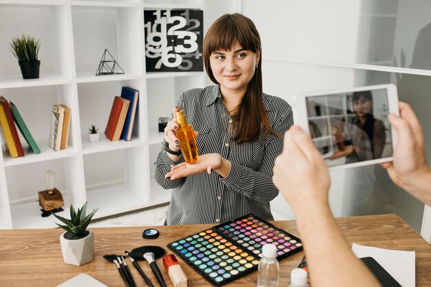 Female make-up blogger with streaming with tablet at home