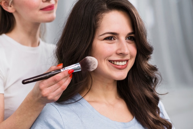 Female makeup artist applying powder 