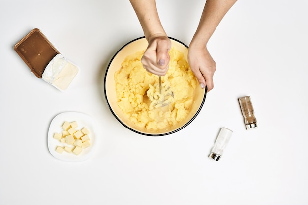 Female making a delicious puree with different ingredients on a white table