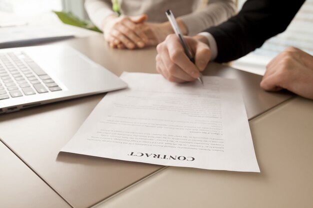Female and male business partners signing contract
