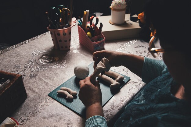 Female master making sculpture from clay