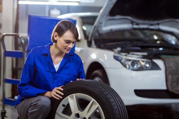 Female mechanic checking a tyre