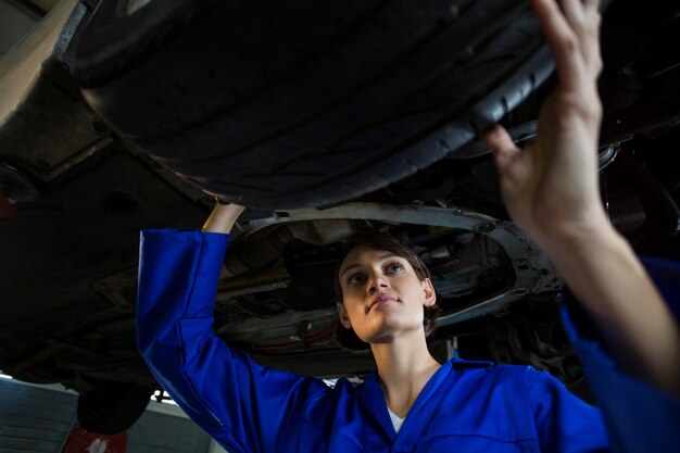 Female mechanic examining a car wheel