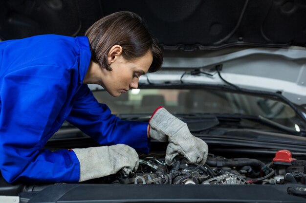 Female mechanic examining a car