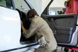 Free photo female mechanic examining a car