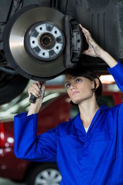 Female mechanic fixing a car wheel disc brake