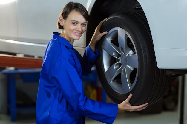 Female mechanic fixing a car wheel