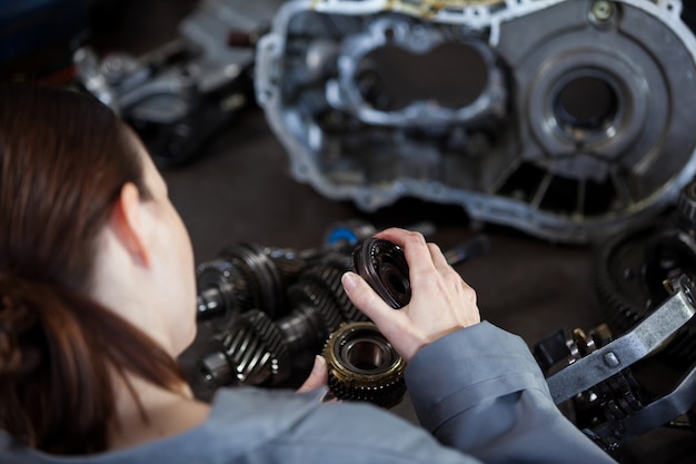 Free photo female mechanic fixing gear