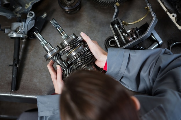 Female mechanic holding spare parts