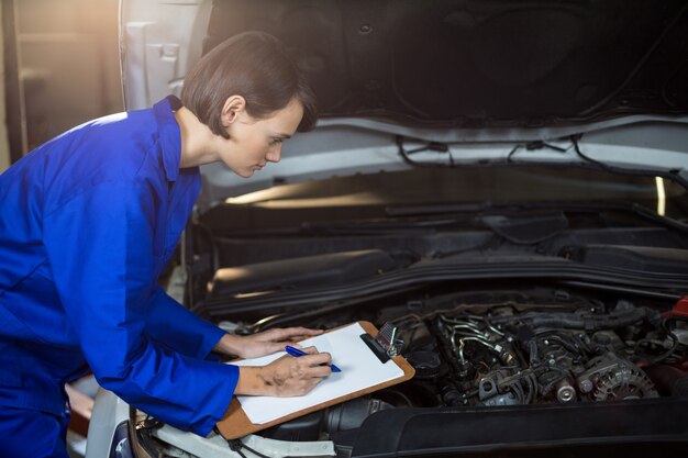 Female mechanic preparing a check list