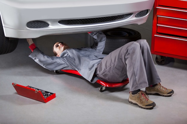 Female mechanic repairing a car