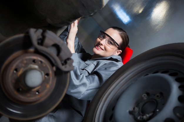 Female mechanic repairing a car