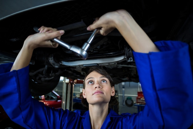 Female mechanic servicing a car