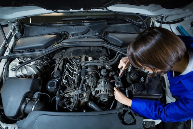 Female mechanic servicing a car