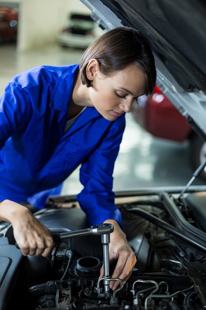 Female mechanic servicing a car