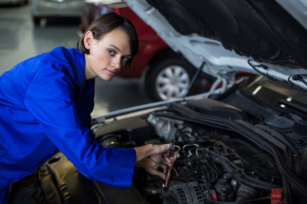 Female mechanic servicing a car