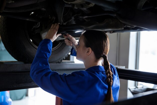 車にサービスを提供する女性メカニック