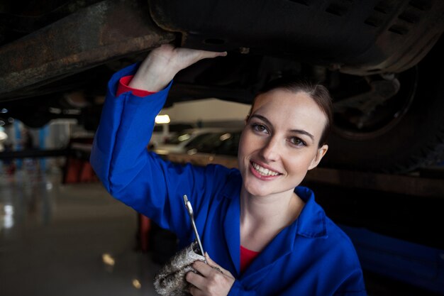 Female mechanic servicing a car